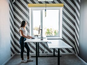 Standing desk for work from home or in office. Young woman programmer working