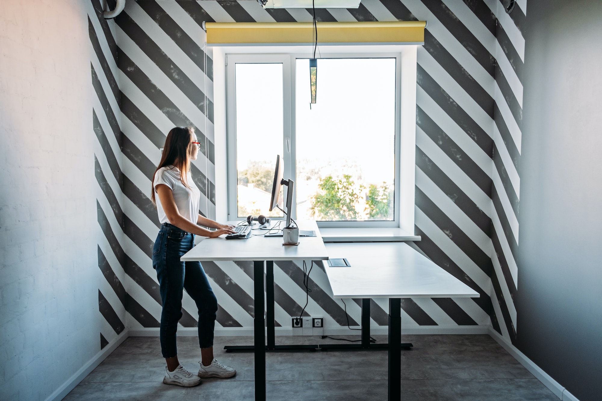 Standing desk for work from home or in office. Young woman programmer working