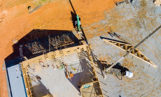 The crane holds a roof truss wood for the roof of the house