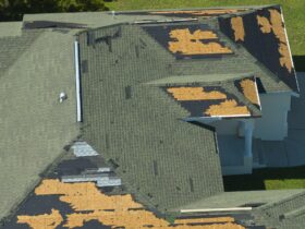 Wind damaged house roof with missing asphalt shingles after hurricane Ian in Florida.