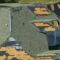 Wind damaged house roof with missing asphalt shingles after hurricane Ian in Florida.