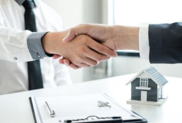 Businessmen and brokers' real estate agents shake hands after completing negotiations to buy houses