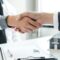 Businessmen and brokers' real estate agents shake hands after completing negotiations to buy houses