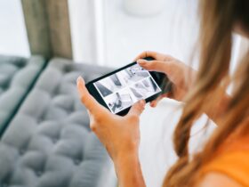 Caucasian woman monitoring security cameras on smartphone indoors, closeup.