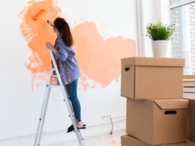 Cheerful woman painting the walls of new home. Renovation, repair and redecoration concept