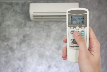 Hand Holding Remote In Front Of Air Conditioner 2022 12 16 03 05 04 Utc