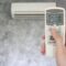 Hand Holding Remote In Front Of Air Conditioner 2022 12 16 03 05 04 Utc