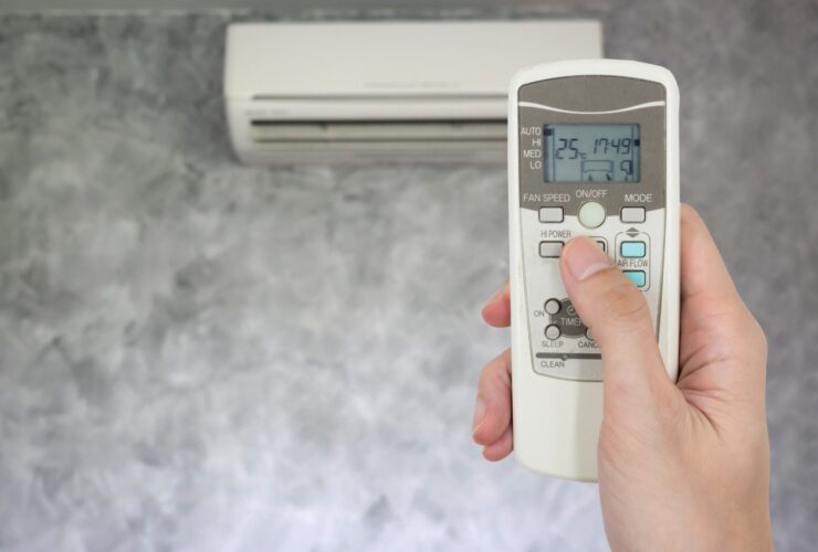 Hand Holding Remote In Front Of Air Conditioner 2022 12 16 03 05 04 Utc