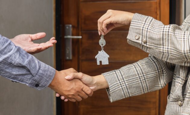 Real estate agents hand over house keys to customers