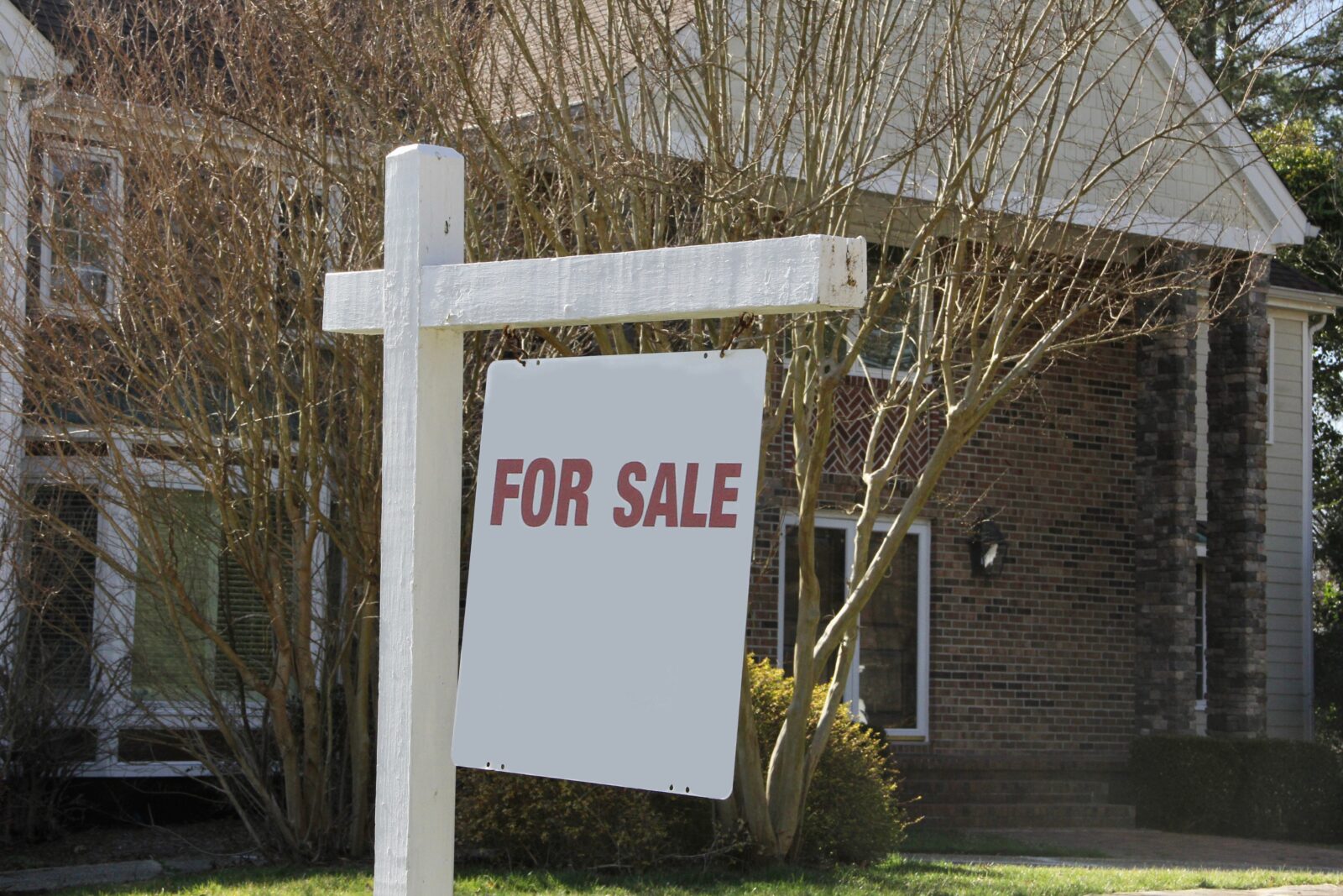 Real estate For Sale sign with copy space with house for sale in background