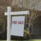 Real estate For Sale sign with copy space with house for sale in background