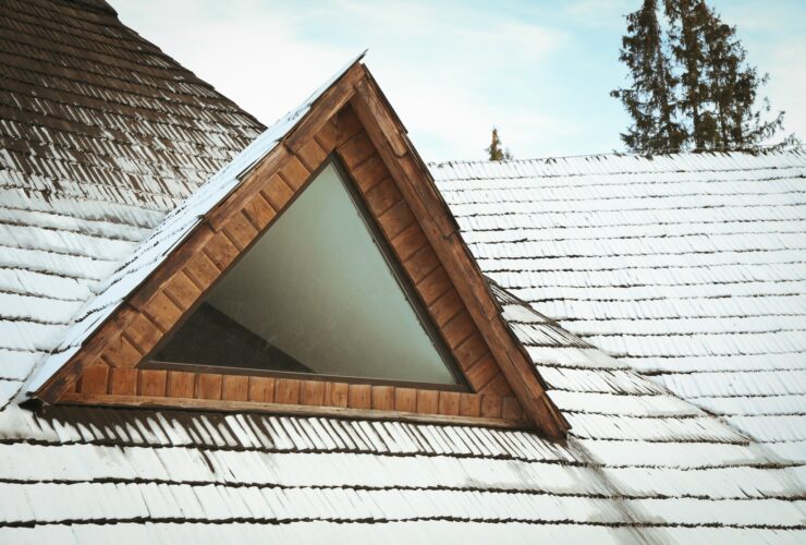 Roof of wooden house with snow in winter day