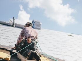 Roofer adding shingles to the roof of a house
