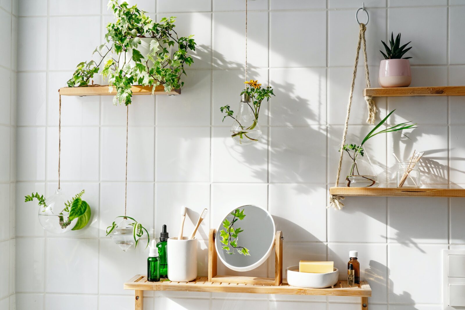 White tile wall with woonden shelves and comstics on them