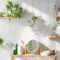 White tile wall with woonden shelves and comstics on them