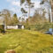 a backyard with a lawn and a small house