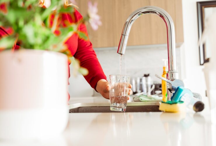 Woman Pouring Tap Water Into Glass In Stylish Kitc 2023 10 31 03 31 39 Utc