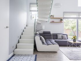 Large, modern sofa in a white living room interior with natural