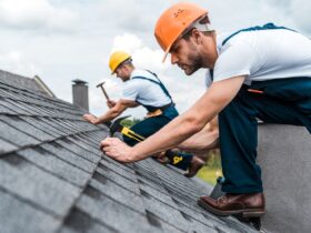 selective focus of handsome handyman repairing roof with coworker