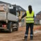 Woman Guides A Reversing Truck On A Residential Building Site