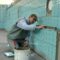 Tiler expertly aligns ceramic tiles on a swimming pool wall. Indoor construction setting in Wrocław.