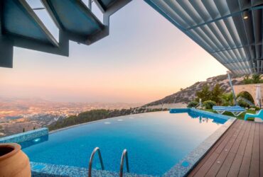 Infinity pool with breathtaking mountain and city views, perfect for a luxury tropical getaway.