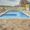 Relaxing poolside patio with sun loungers and villas, perfect for a summer retreat.