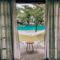 Charming poolside view through curtains with hammock and seating, ideal for a summer vacation.