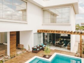 Contemporary interior of lounge area with swimming pool located on terrace of luxury villa in sunny day