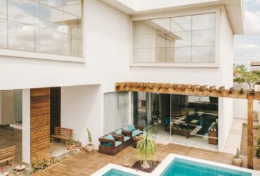 Contemporary interior of lounge area with swimming pool located on terrace of luxury villa in sunny day