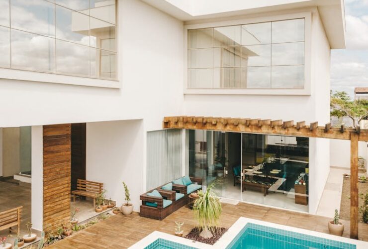 Contemporary interior of lounge area with swimming pool located on terrace of luxury villa in sunny day
