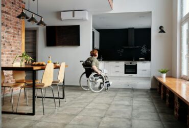 photo of woman on wheelchair going to the kitchen