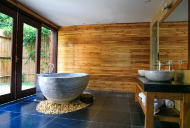 Elegant bathroom showcasing a modern marble tub and wooden interior for a serene escape.
