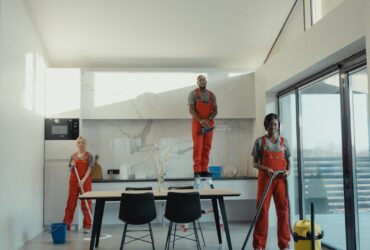 Team of professional cleaners working in a spacious, modern indoor setting.