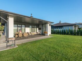 A modern house with a wide patio and neatly landscaped backyard, ideal for real estate and architecture themes.