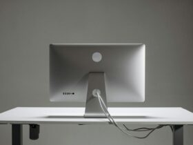 A clean, minimalist setup featuring a silver computer on a sleek white desk.