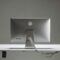 A clean, minimalist setup featuring a silver computer on a sleek white desk.