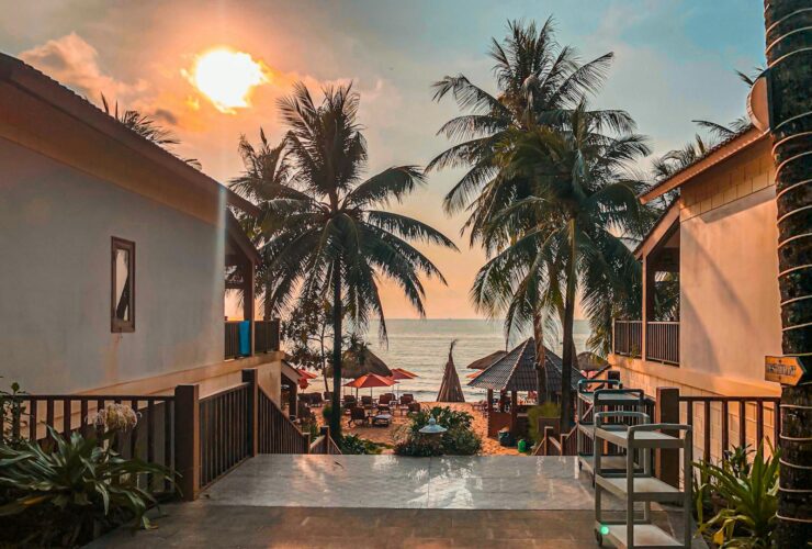 Beautiful sunset over palm-lined beach at Phu Quoc resort, Vietnam, capturing a serene and tropical atmosphere.