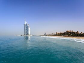 Iconic Burj Al Arab overlooking the pristine Dubai beach, perfect for travel and leisure.