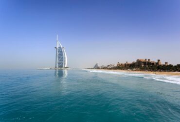 Iconic Burj Al Arab overlooking the pristine Dubai beach, perfect for travel and leisure.