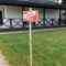 A modern house with a sold sign on a grassy lawn, indicating property purchase.