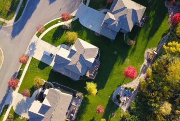 A picturesque aerial view showcasing suburban homes with vibrant gardens and tree-lined streets.