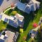 A picturesque aerial view showcasing suburban homes with vibrant gardens and tree-lined streets.