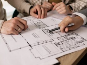 People discuss architectural plans in a real estate planning session, highlighting teamwork.