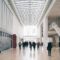 Spacious art gallery lobby with visitors in a modern architectural setting.