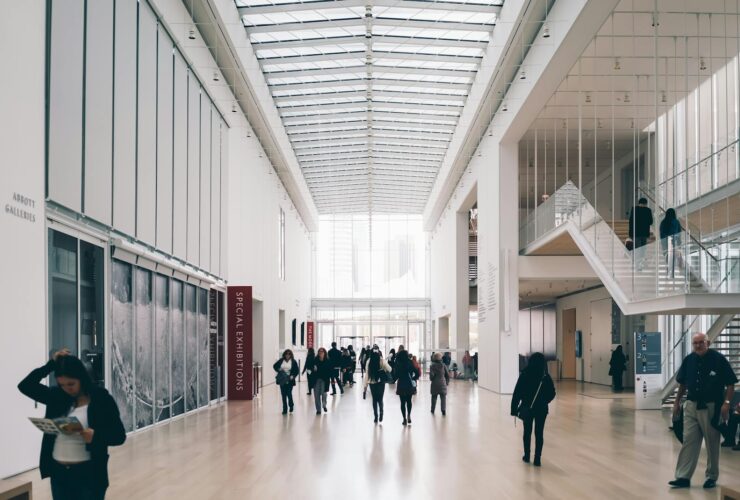 Spacious art gallery lobby with visitors in a modern architectural setting.
