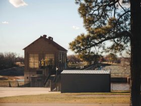 Charming view of a historic building near Lake Overholser Dam, Oklahoma City, with clear skies and lush greenery.