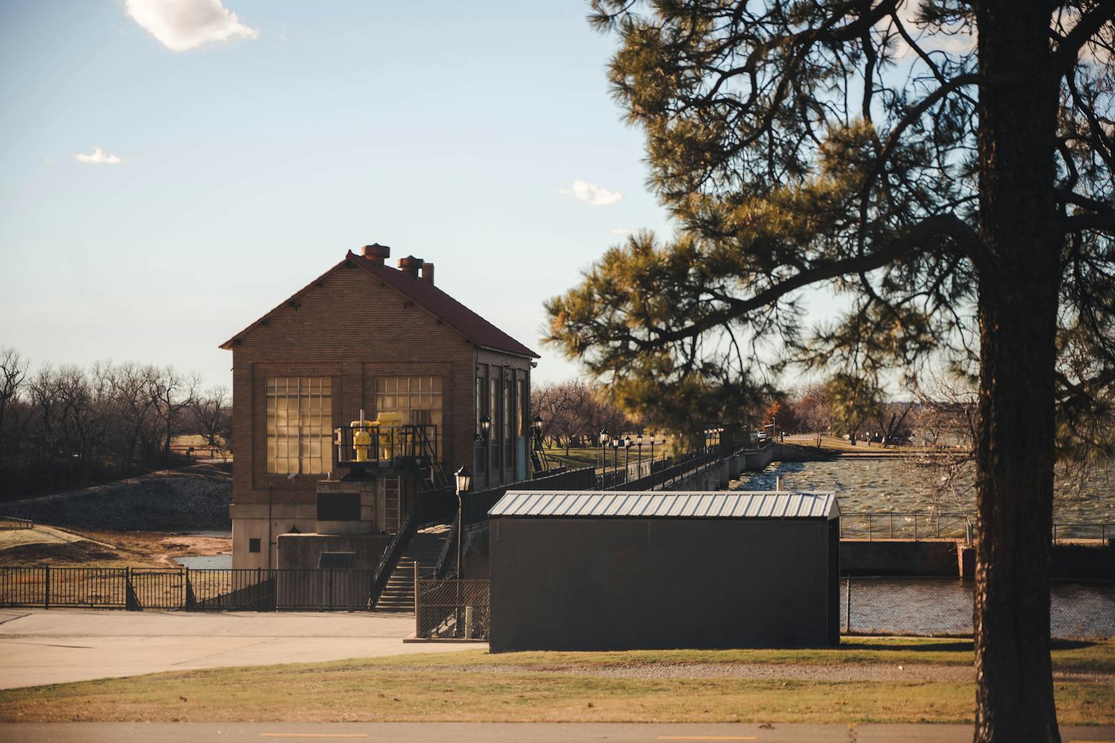 Charming view of a historic building near Lake Overholser Dam, Oklahoma City, with clear skies and lush greenery.