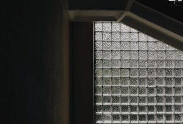 Dramatic staircase with industrial design and textured glass block windows.