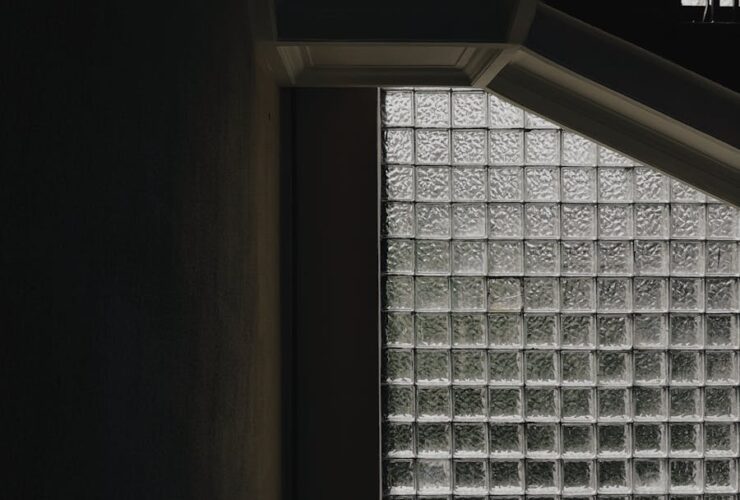 Dramatic staircase with industrial design and textured glass block windows.